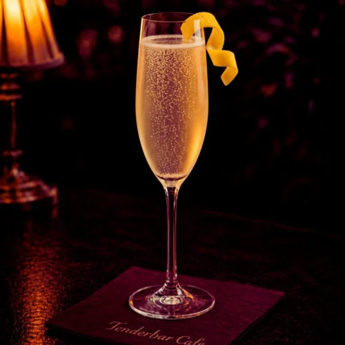 French 75 koktel u flute čaši sa šampanjcem, džinom i limunom, lagano penušav i ukrašen twistom limuna.